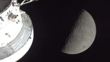 Fotografía cedida por la NASA de una instantánea capturada por la tripulación de la misión Artemis II este lunes, que muestra la Luna en fase de creciente junto a la nave espacial Orion.