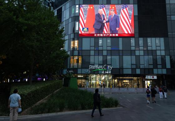 People walk in front of a TV screen broadcasting the summit between US President Donald Trump (L) and Chinese President Xi Jinping, in Beijing, China, 14 May 2026. US President Trump is in Beijing for a high-stakes state visit running through 15 May, marking his first return to the mainland since 2017.